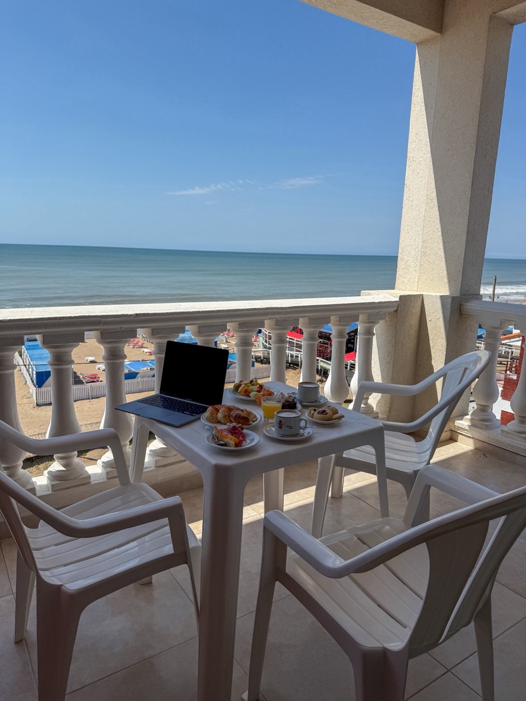 Balcón de una habitación con vista al mar y desayuno servido